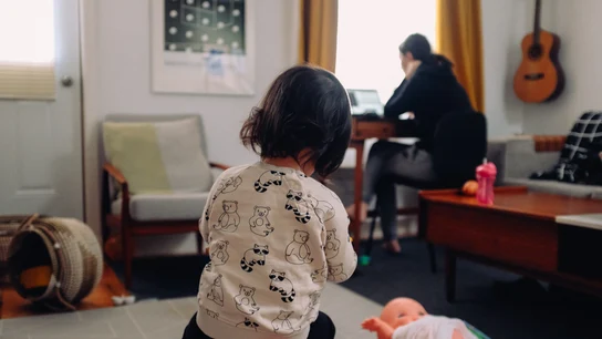 Una niña juega mientras su madre trabaja en casa conciliacion