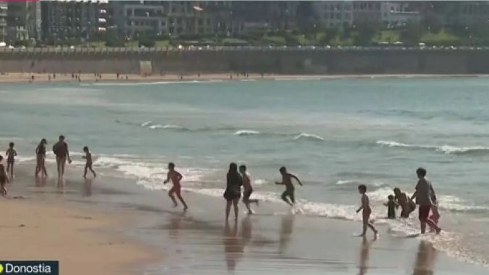 Niños abandonan a la carrera el agua en la playa de Donostia