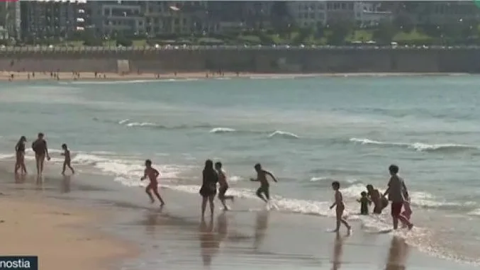 Niños abandonan a la carrera el agua en la playa de Donostia