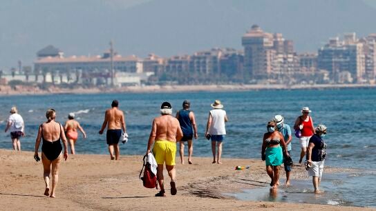 Ciudadanos pasean por la playa de Benidorm