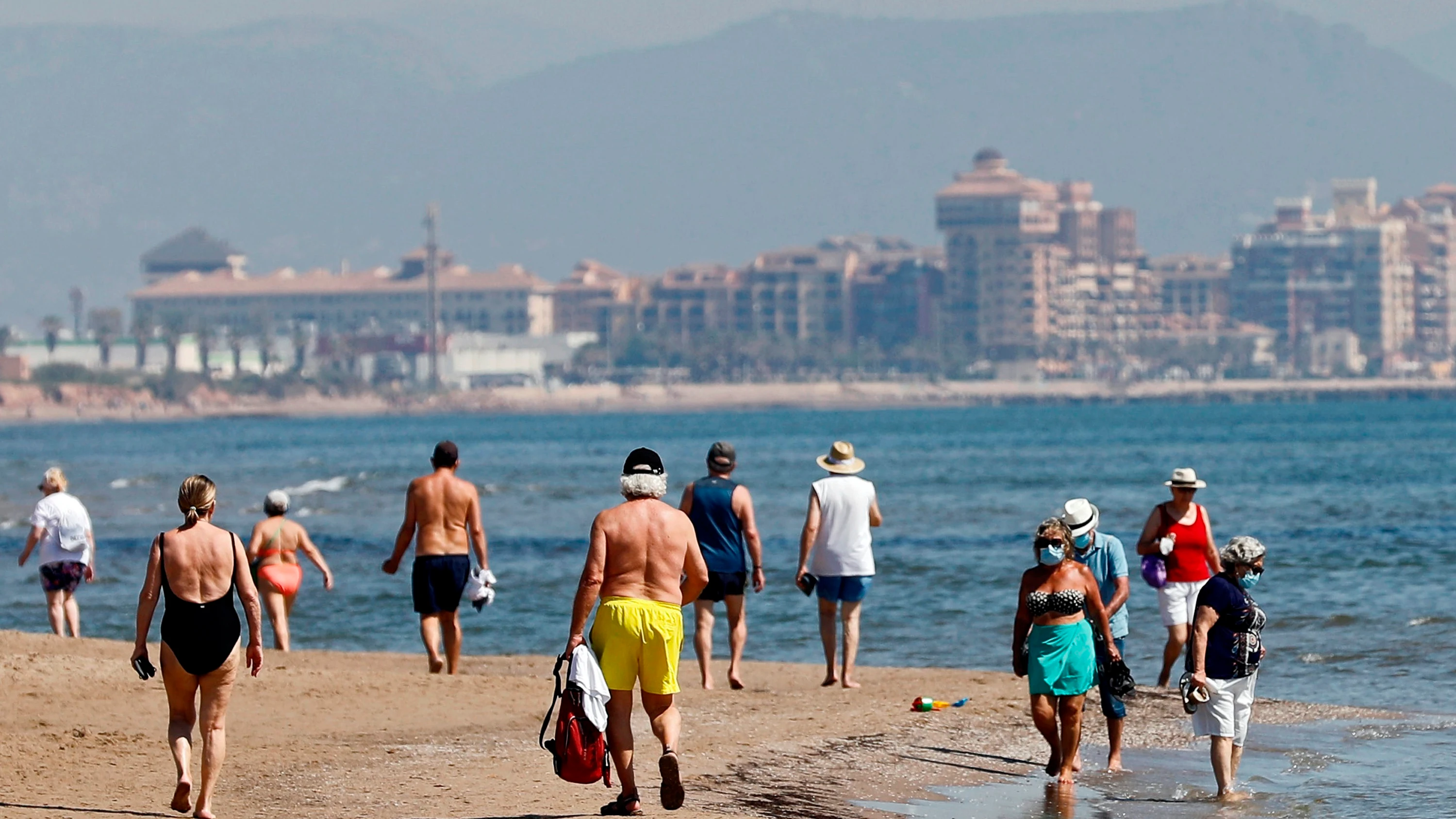 Ciudadanos pasean por la playa de Benidorm