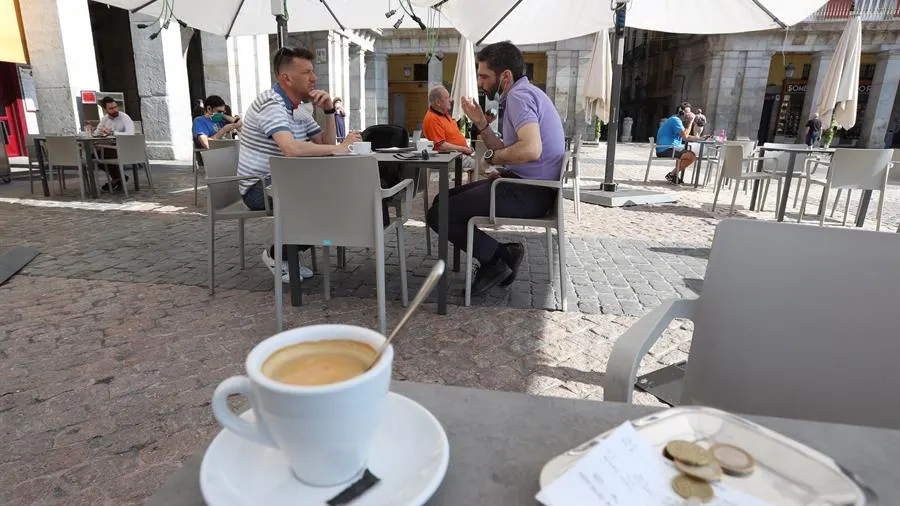  Varias personas disfrutan de la terraza de un bar.