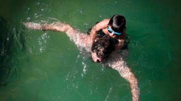 Un hombre y su hijo se bañan en la playa de La Concha de San Sebastián