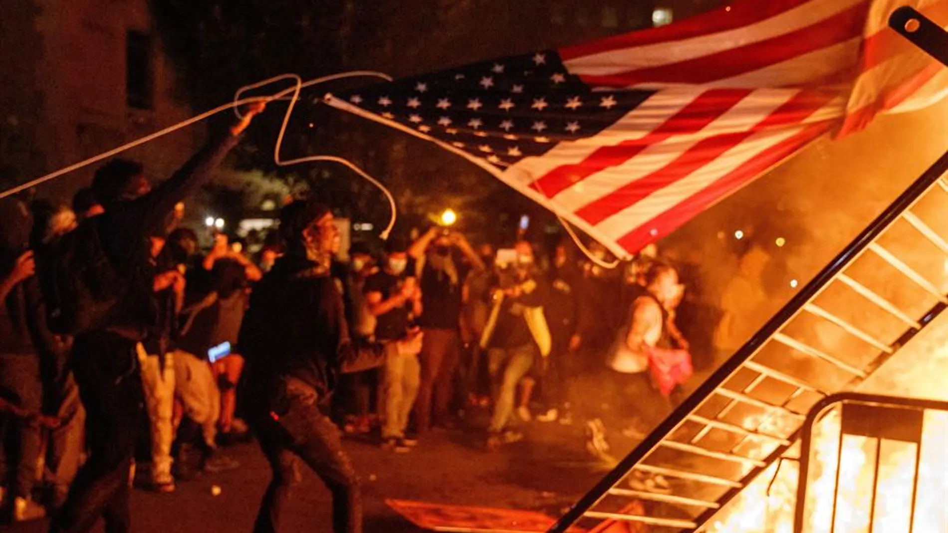 Arrojan una bandera de Estados Unidos al fuego durante una manifestación