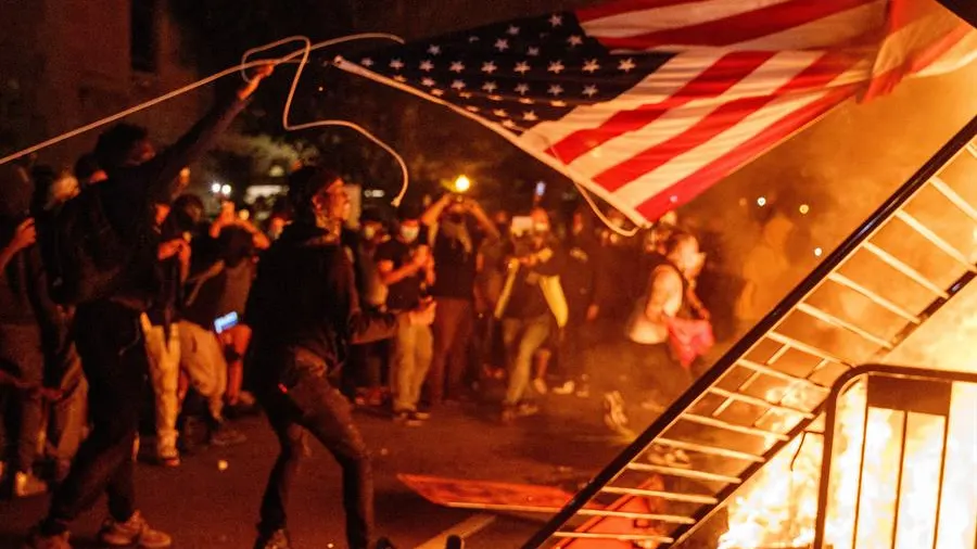 Arrojan una bandera de Estados Unidos al fuego durante una manifestación