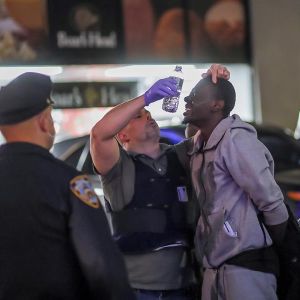 Oficiales del Departamento de Policía de Nueva York prestan ayuda a un detenido Oficiales del Departamento de Policía de Nueva York prestan ayuda a un detenido