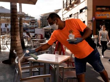 Un camarero desinfecta unas sillas de una terraza de un bar de Puerto de la Cruz, en Tenerife. Un camarero desinfecta unas sillas de una terraza de un bar de Puerto de la Cruz, en Tenerife.