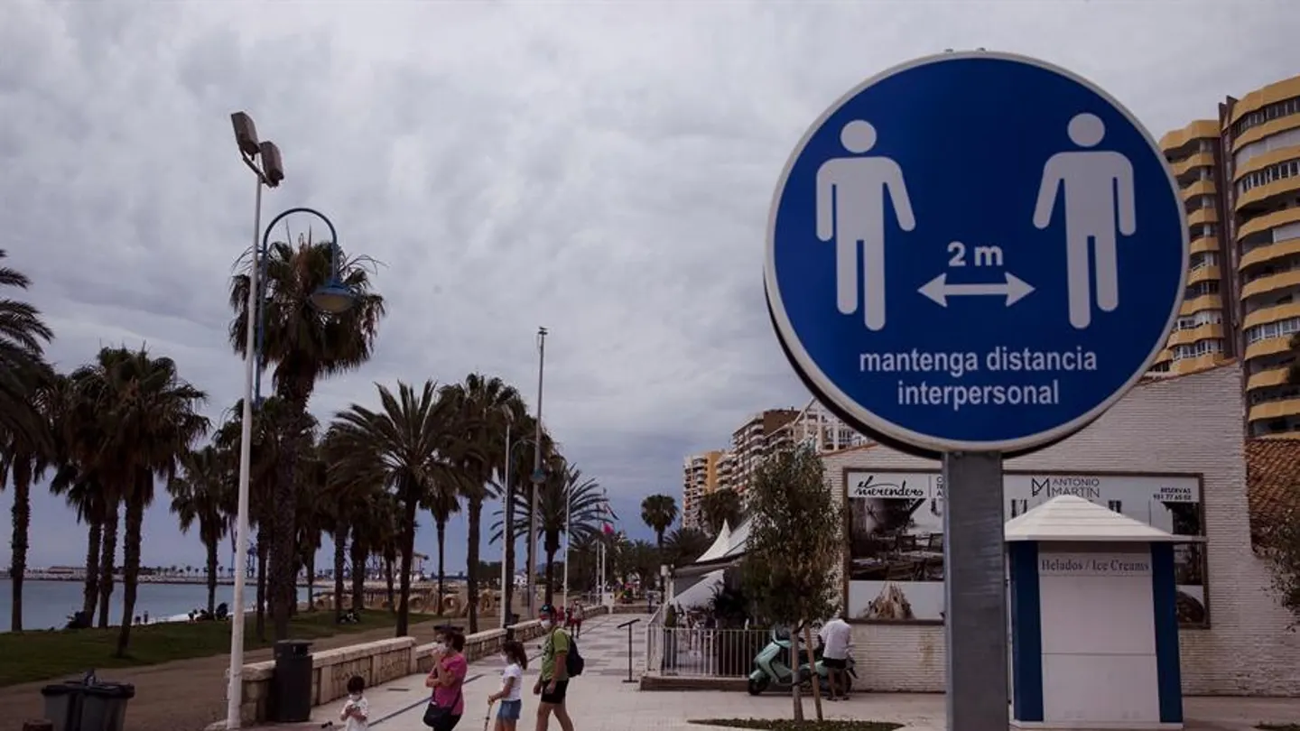 Una familia en el paseo marítimo de la Malagueta ante un disco que recuerda mantener la distancia de 2 metros entre personas Una familia en el paseo marítimo de la Malagueta ante un disco que recuerda mantener la distancia de 2 metros entre personas