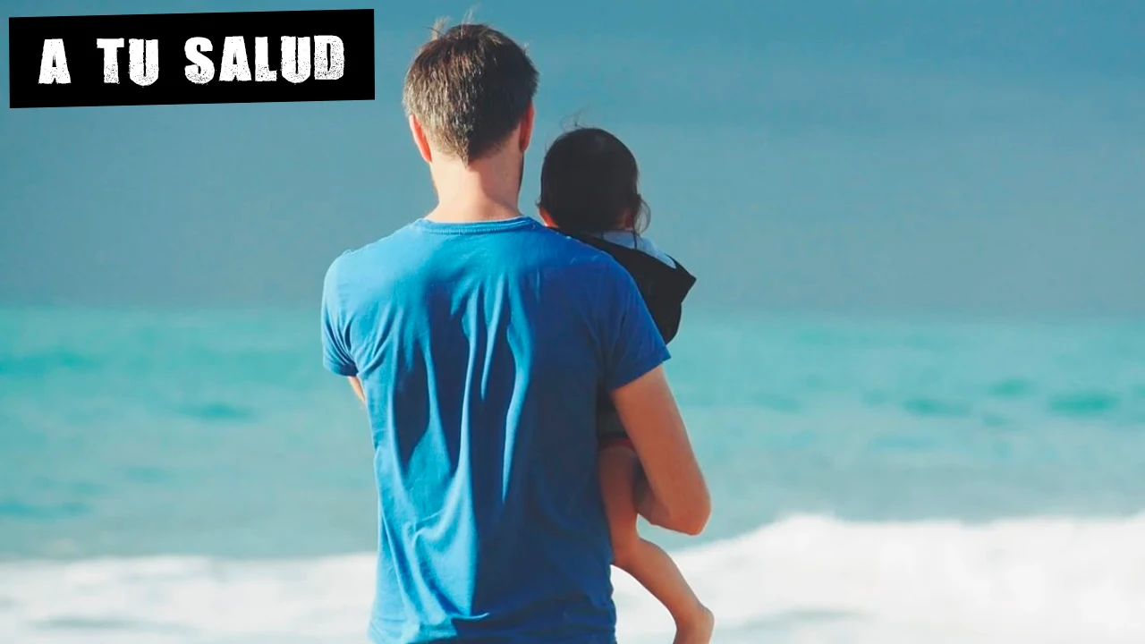 Imagen de un hombre con un niño en la playa