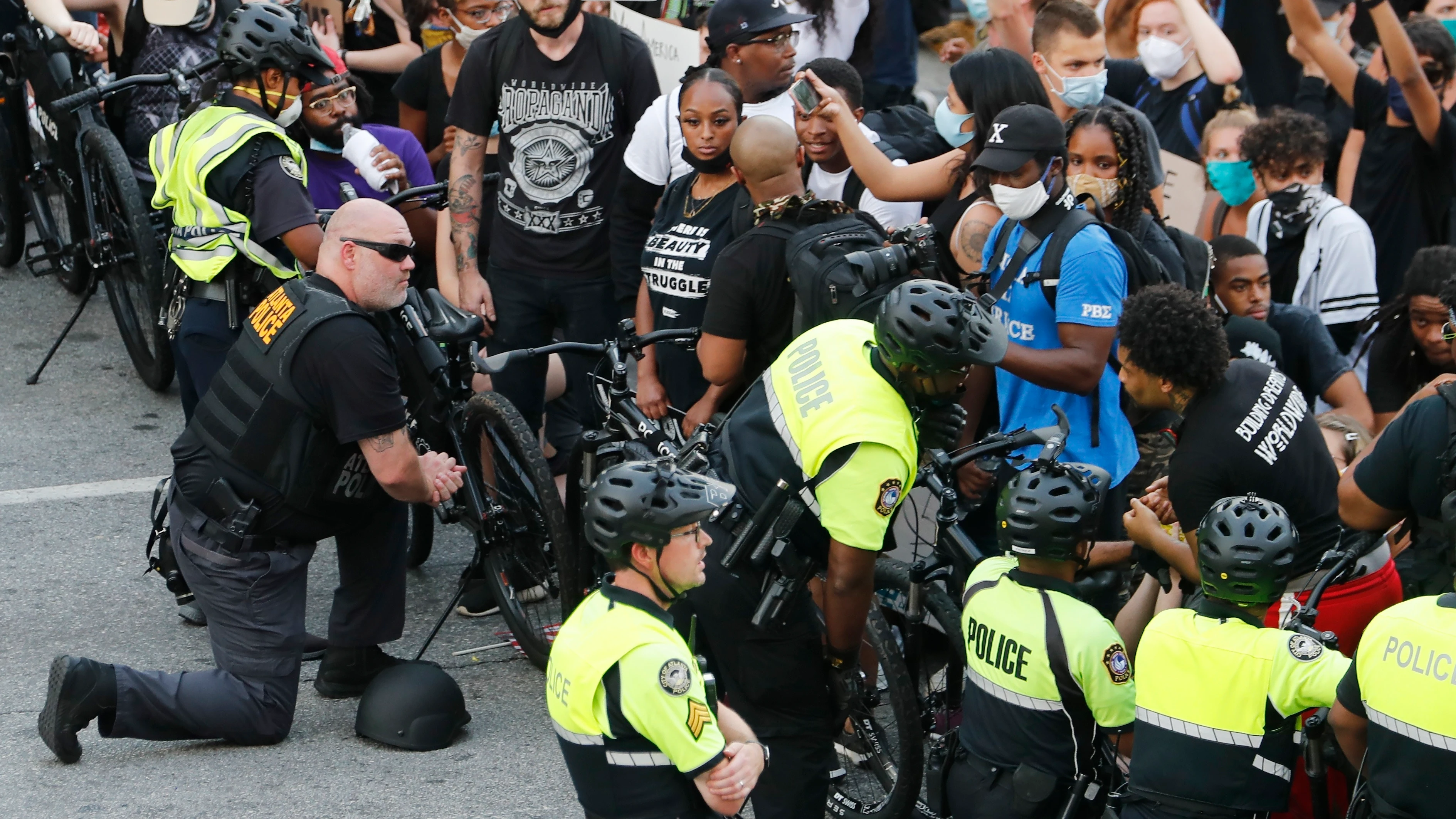  Policías se arrodillan frente a manifestantes que protestan contra la violencia racial