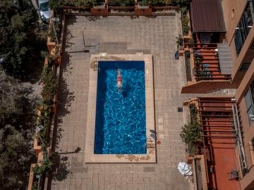 Una persona se baña en una piscina comunitaria en la Comunitat Valenciana Una persona se baña en una piscina comunitaria en la Comunitat Valenciana