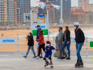 Un grupo de personas pasean por el paseo marítimo de la playa de San Lorenzo de Gijón . Un grupo de personas pasean por el paseo marítimo de la playa de San Lorenzo de Gijón .
