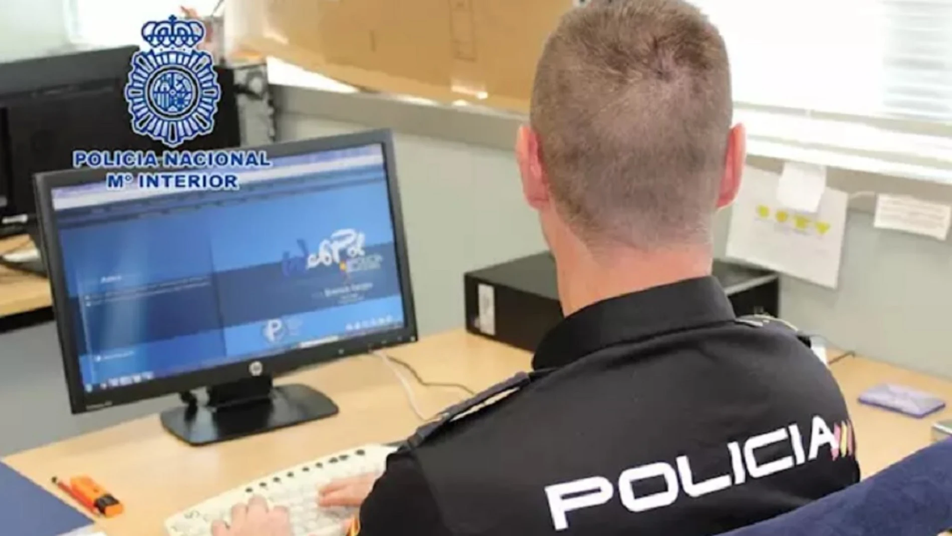 Imagen de archivo de un policía frente a un ordenador