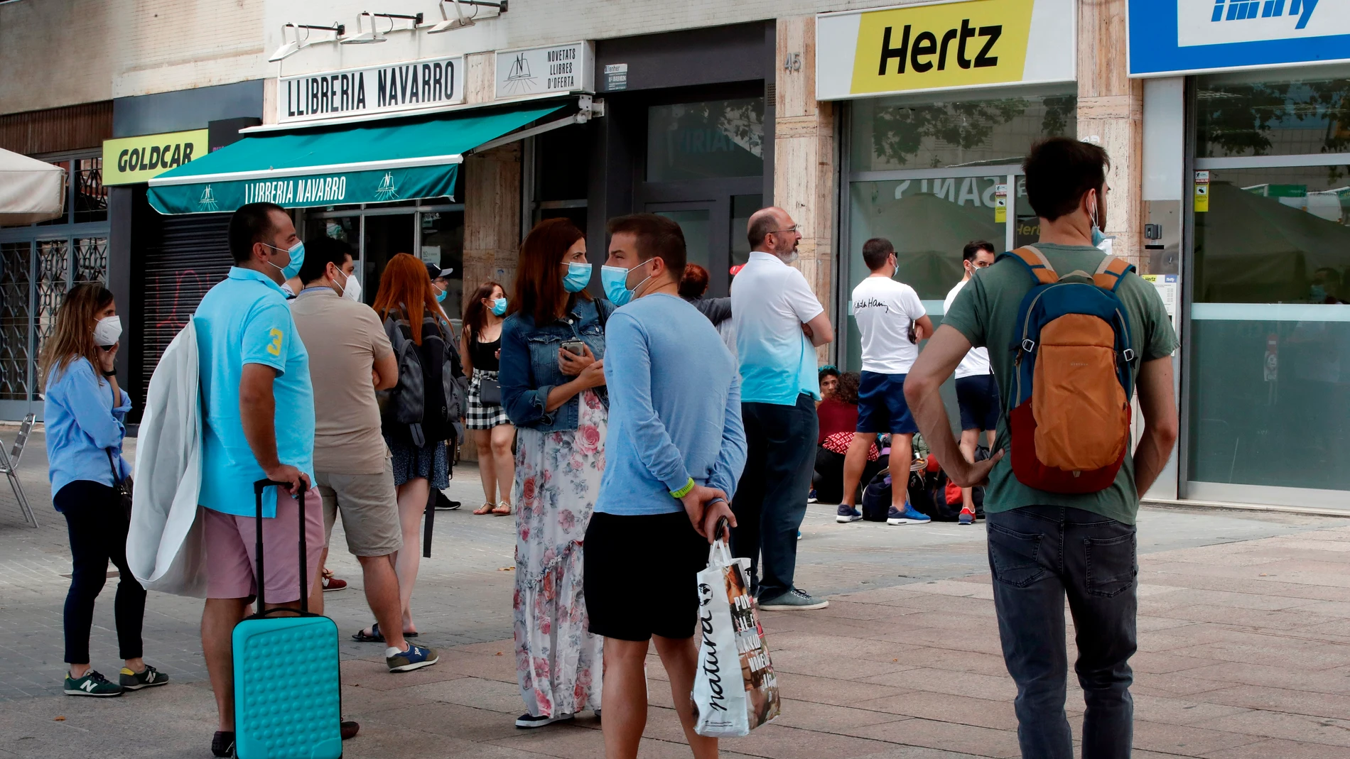 Varias personas hacen cola ante una central de Hertz ubicada en las inmediaciones de la estación de Sants de Barcelona