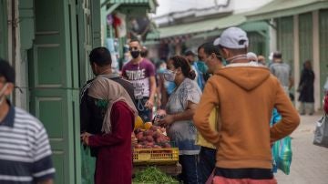 Varias personas con mascarillas compran fruta en Rabat (Marruecos)