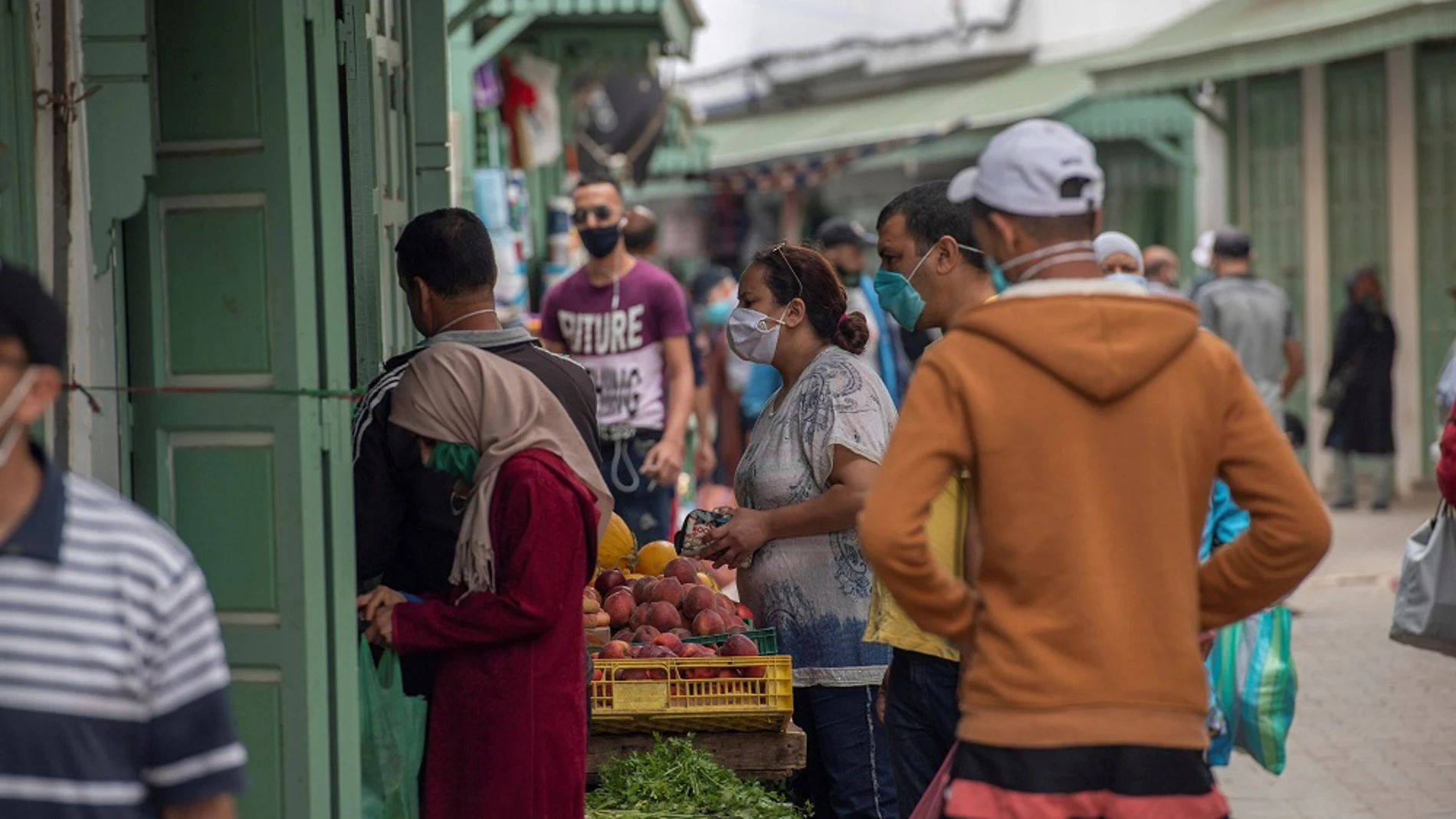 Varias personas con mascarillas compran fruta en Rabat (Marruecos)