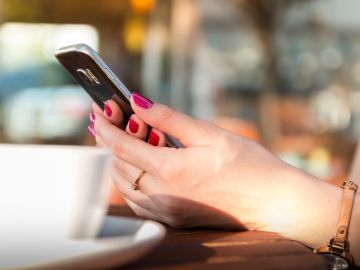 Imagen de una mujer usando un teléfono móvil en un bar Imagen de una mujer usando un teléfono móvil en un bar