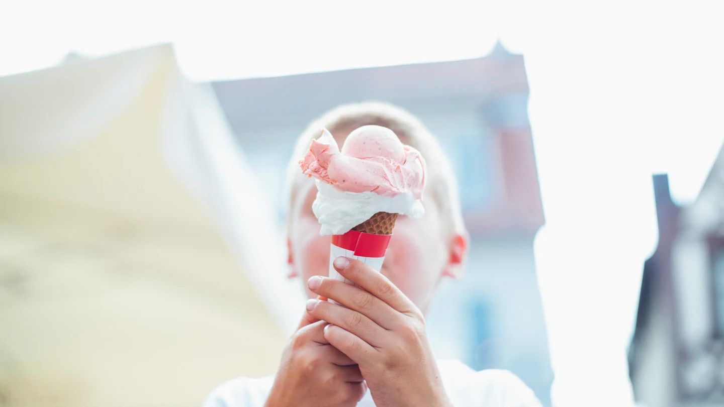 Un niño come un helado en la calle Niño