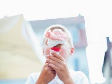 Un niño come un helado en la calle