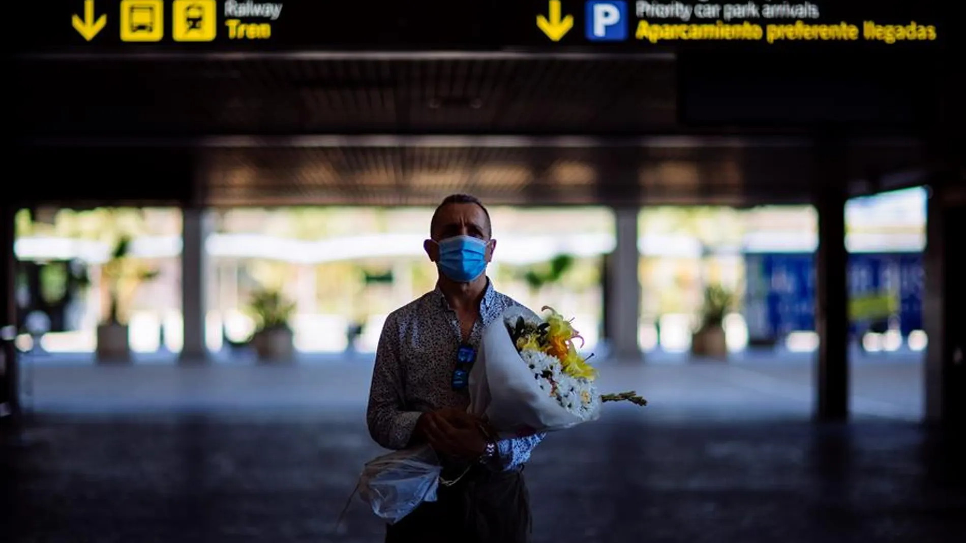 Un hombre espera la llegada de su pareja en el aeropuerto de Málaga-Costa del Sol 
