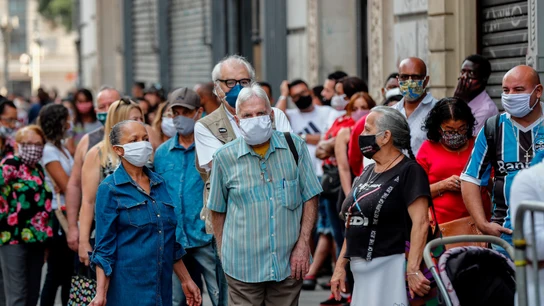 Un grupo de personas esperan en la fila para ingresar a un centro comercial en la ciudad de Sao Paulo (Brasil). Un grupo de personas esperan en la fila para ingresar a un centro comercial en la ciudad de Sao Paulo (Brasil).