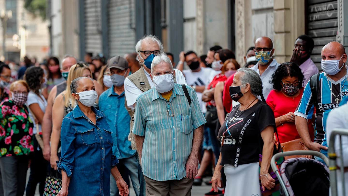 Un grupo de personas esperan en la fila para ingresar a un centro comercial en la ciudad de Sao Paulo (Brasil). Un grupo de personas esperan en la fila para ingresar a un centro comercial en la ciudad de Sao Paulo (Brasil).