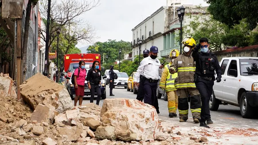 Miembros de la policía y de los bomberos observan los daños causados en un derrumbe en la ciudad de Oaxaca (México).