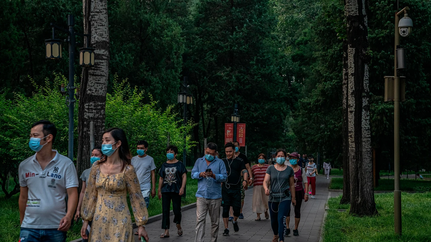 Un grupo de personas con mascarilla pasea por Pekín Un grupo de personas con mascarilla pasea por Pekín