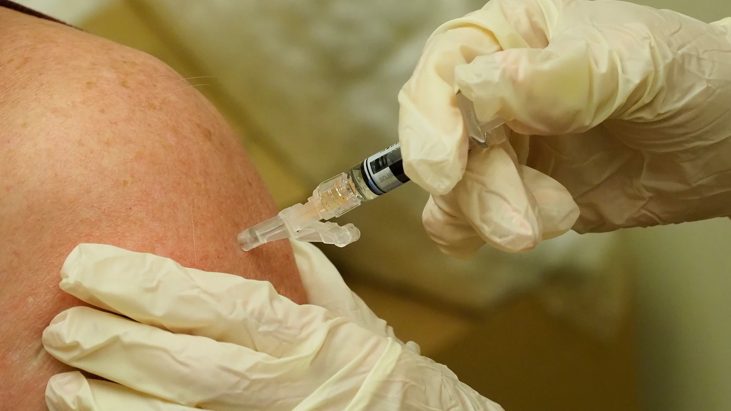 Un sanitario vacuna a un paciente Un sanitario vacuna a un paciente