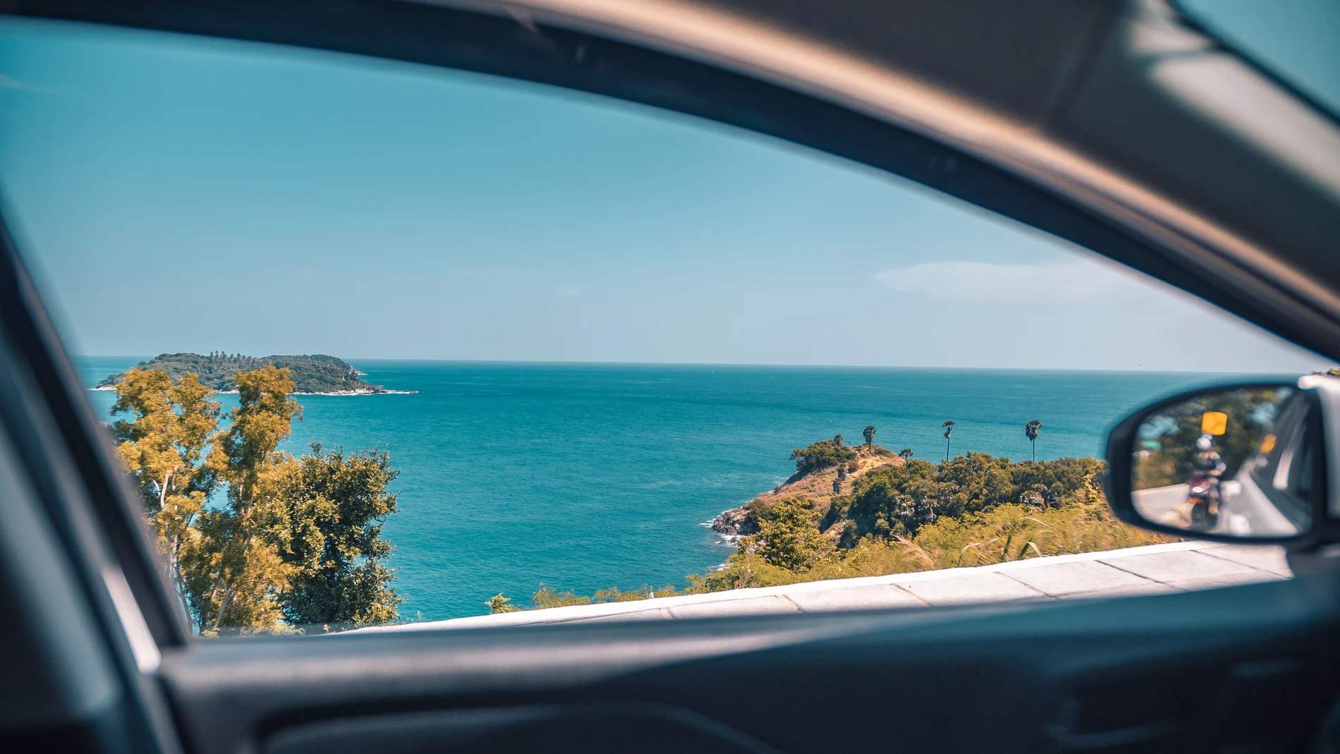 Vistas del mar desde la ventanilla lateral de un coche
