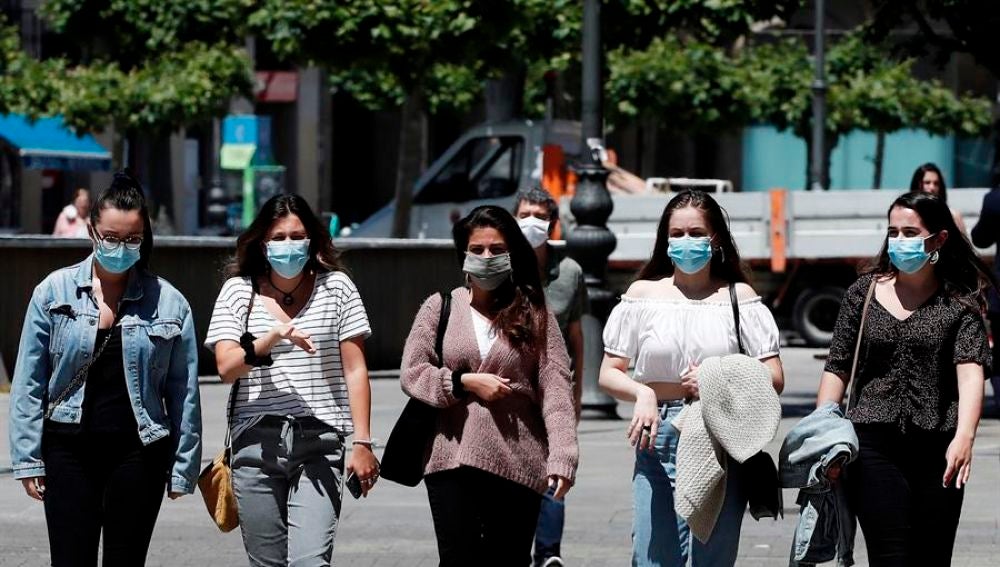 Jóvenes con mascarilla pasean por Pamplona