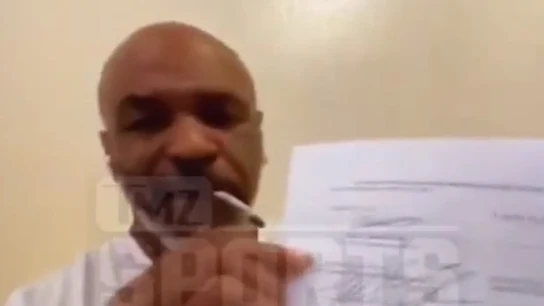 Mike Tyson muestra el contrato de su vuelta al ring mientras se fuma un porro Mike Tyson muestra el contrato de su vuelta al ring mientras se fuma un porro