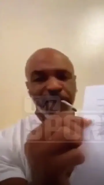 Mike Tyson muestra el contrato de su vuelta al ring mientras se fuma un porro Mike Tyson muestra el contrato de su vuelta al ring mientras se fuma un porro