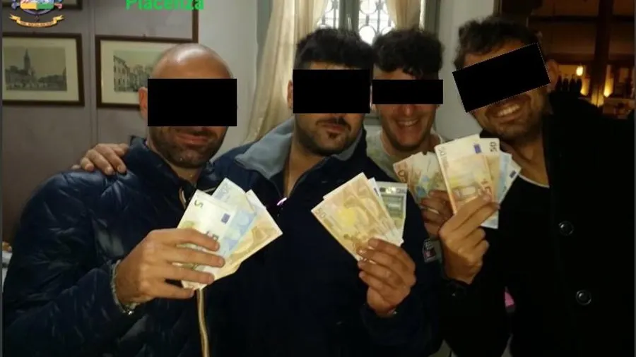 Imagen facilitada por la Guardia de Finanzas de cuatro de los carabineros arrestados mostrando dinero. 