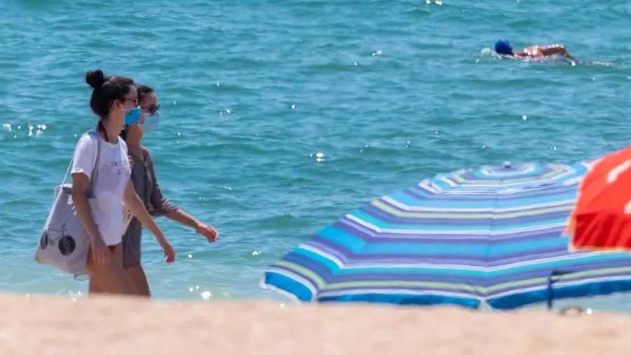 Dos jóvenes con mascarilla en una playa de Andalucía Dos jóvenes con mascarilla, obligatoria en las playas de Andalucía