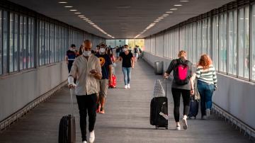 Varios pasajeros en uno de los pasillos de la T2 del Aeropuerto de El Prat