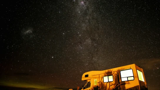 Una autocaravana aparcada bajo un manto de estrellas en verano Guía para viajar en autocaravana este verano