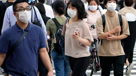 Peatones con mascarilla en una calle de Tokio Peatones con mascarilla en una calle de Tokio