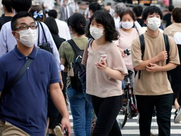 Peatones con mascarilla en una calle de Tokio Peatones con mascarilla en una calle de Tokio