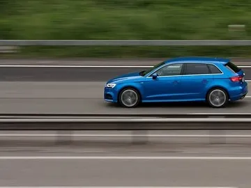 Coche circulando por una vía a gran velocidad Coche circulando por una vía a gran velocidad