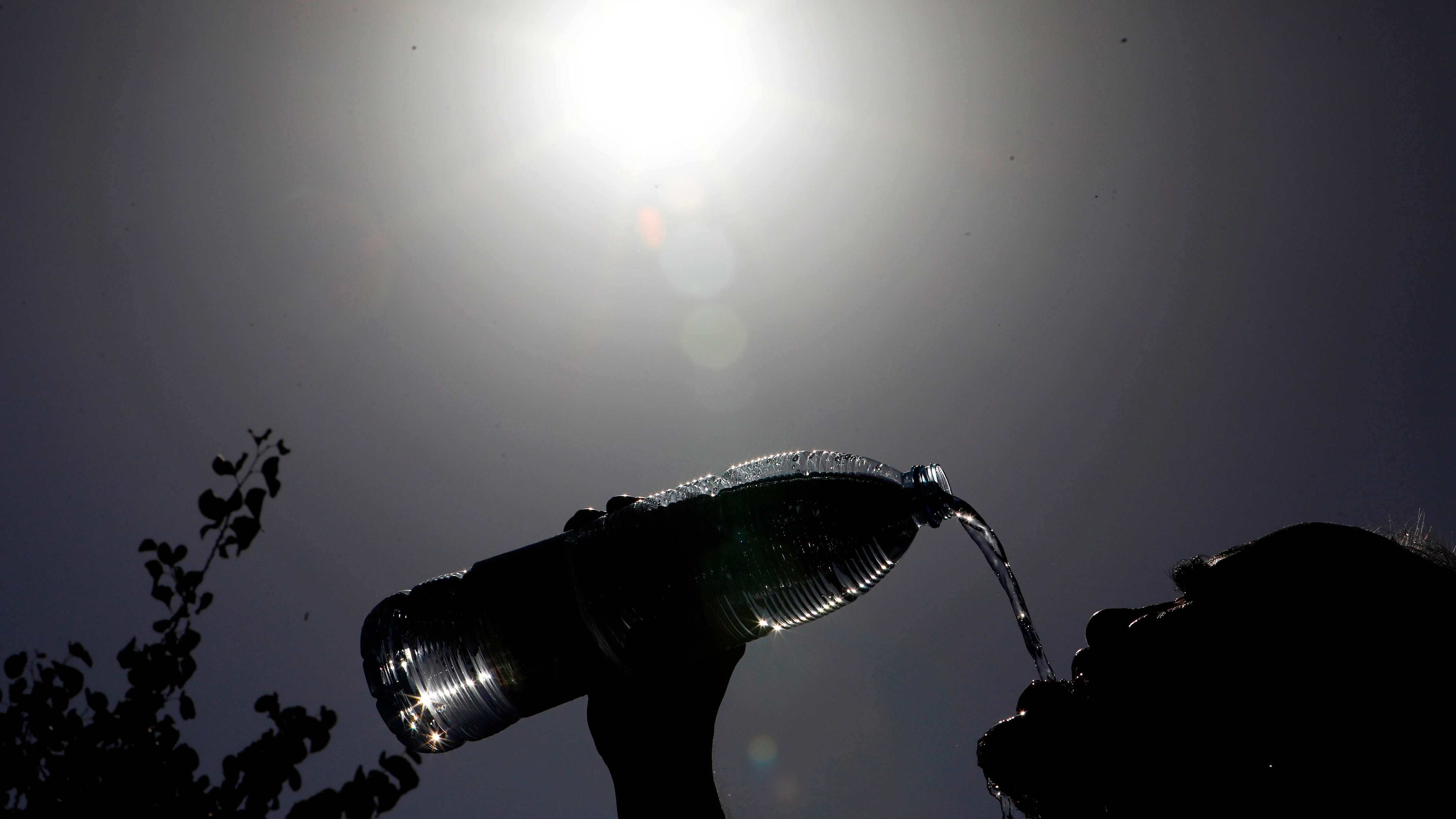 Un hombre se refresca de las alta temperaturas.