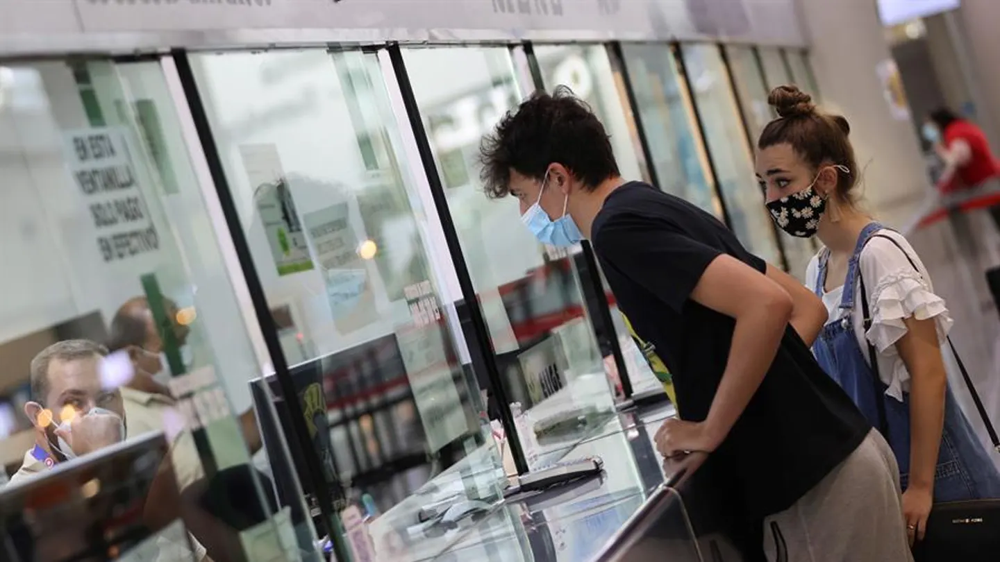 Dos personas compran billetes para viajar en autobús en la Estación Sur de Madrid Dos personas compran billetes para viajar en autobús en la Estación Sur de Madrid