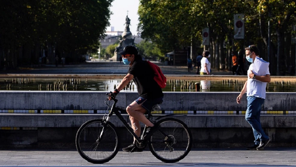 Un hombre circula en bicicleta y con mascarilla por el centro de la ciudad de Valladolid