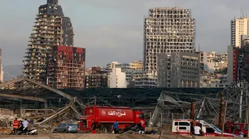 Un camión de bomberos aparcado en las inmediaciones de unos edificios dañados por la explosión.