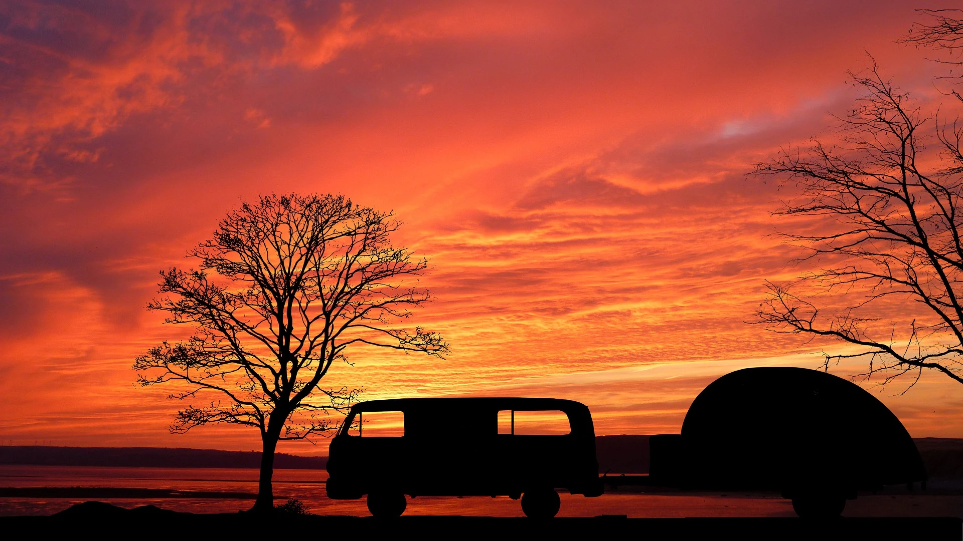 Imagen de una caravana en un rojo atardecer