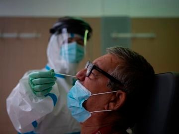 Una profesional sanitaria realiza una prueba PCR. Una profesional sanitaria realiza una prueba PCR.