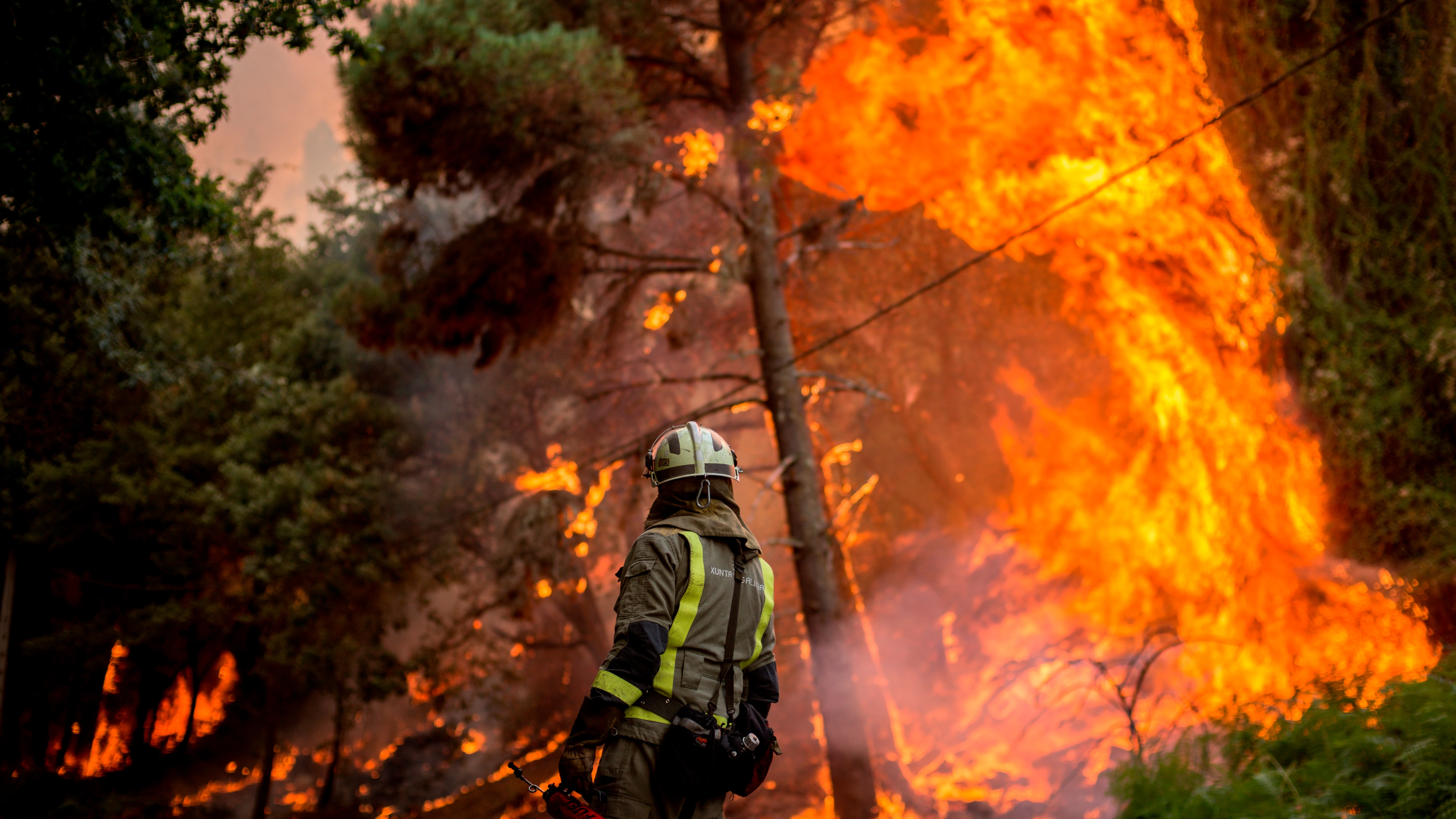 Un bombero realiza labores de extinción en el incendio forestal que permanece activo en el municipio orensano de Toén