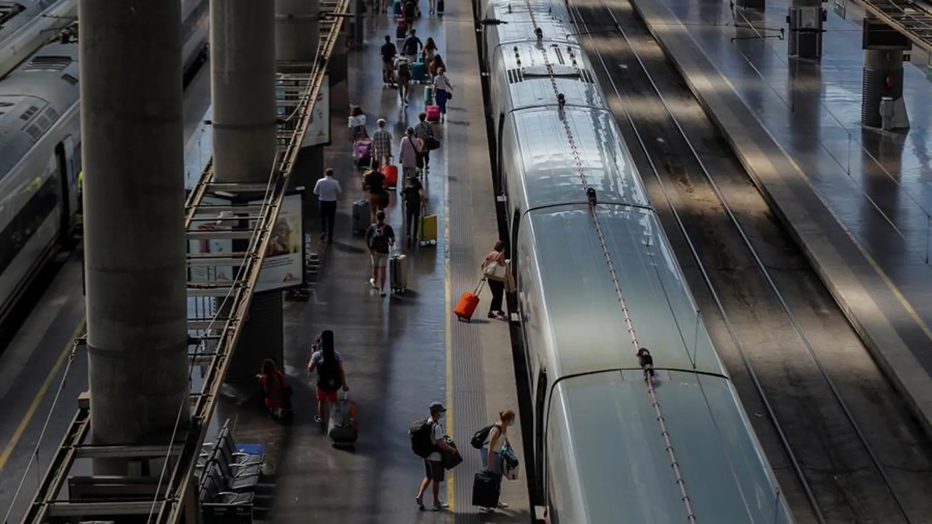 Varias personas suben al AVE en la Estación de Atocha en Madrid.