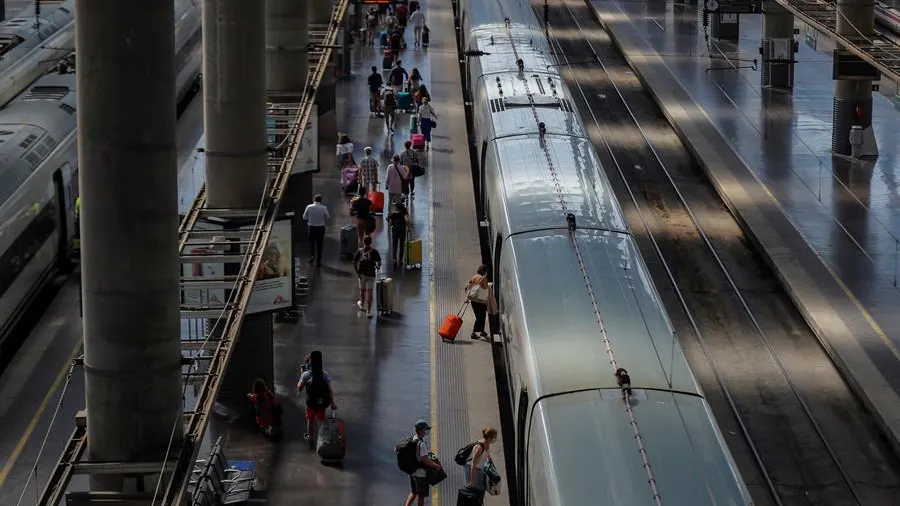 Varias personas suben al AVE en la Estación de Atocha en Madrid.