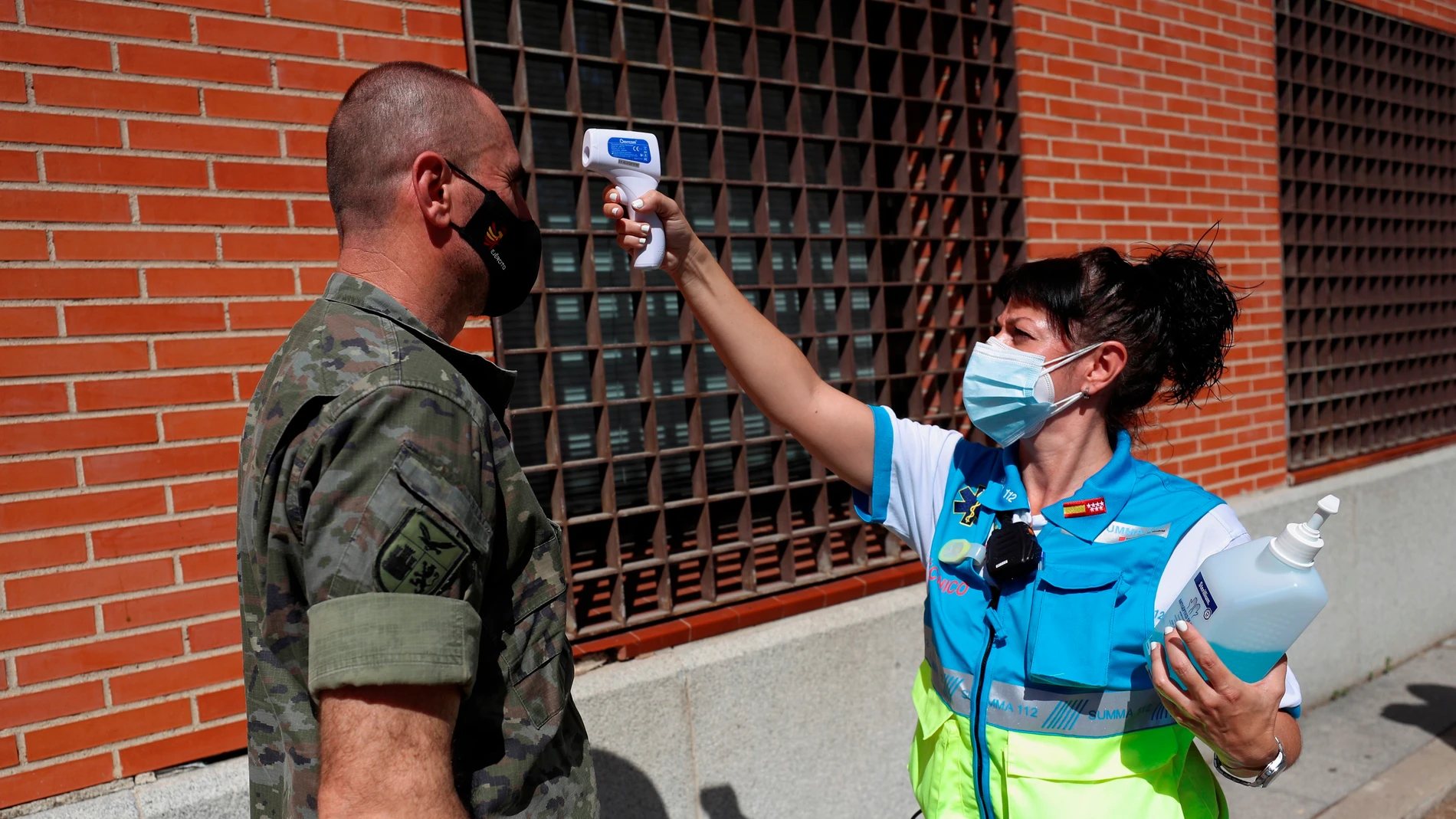 Una sanitaria toma la temperatura a un militar antes de realizarse una PCR en Villaverde